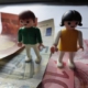 Zwei Playmobilfiguren auf Geldscheinen.