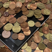 Mobiltelefon in einem Haufen Münzen liegend.
